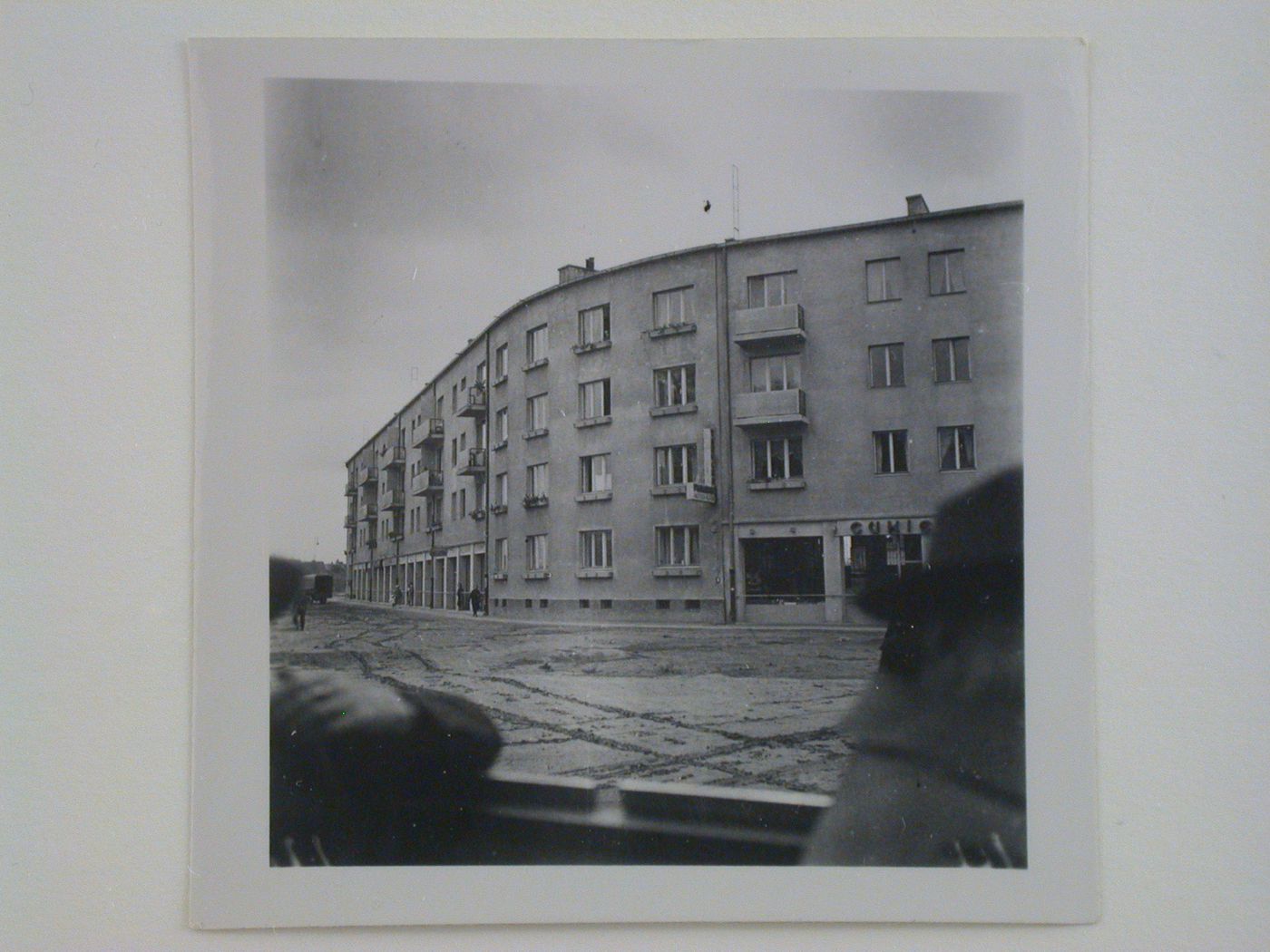 Exterior view of an unidentified multifunctional building showing stores and apartments