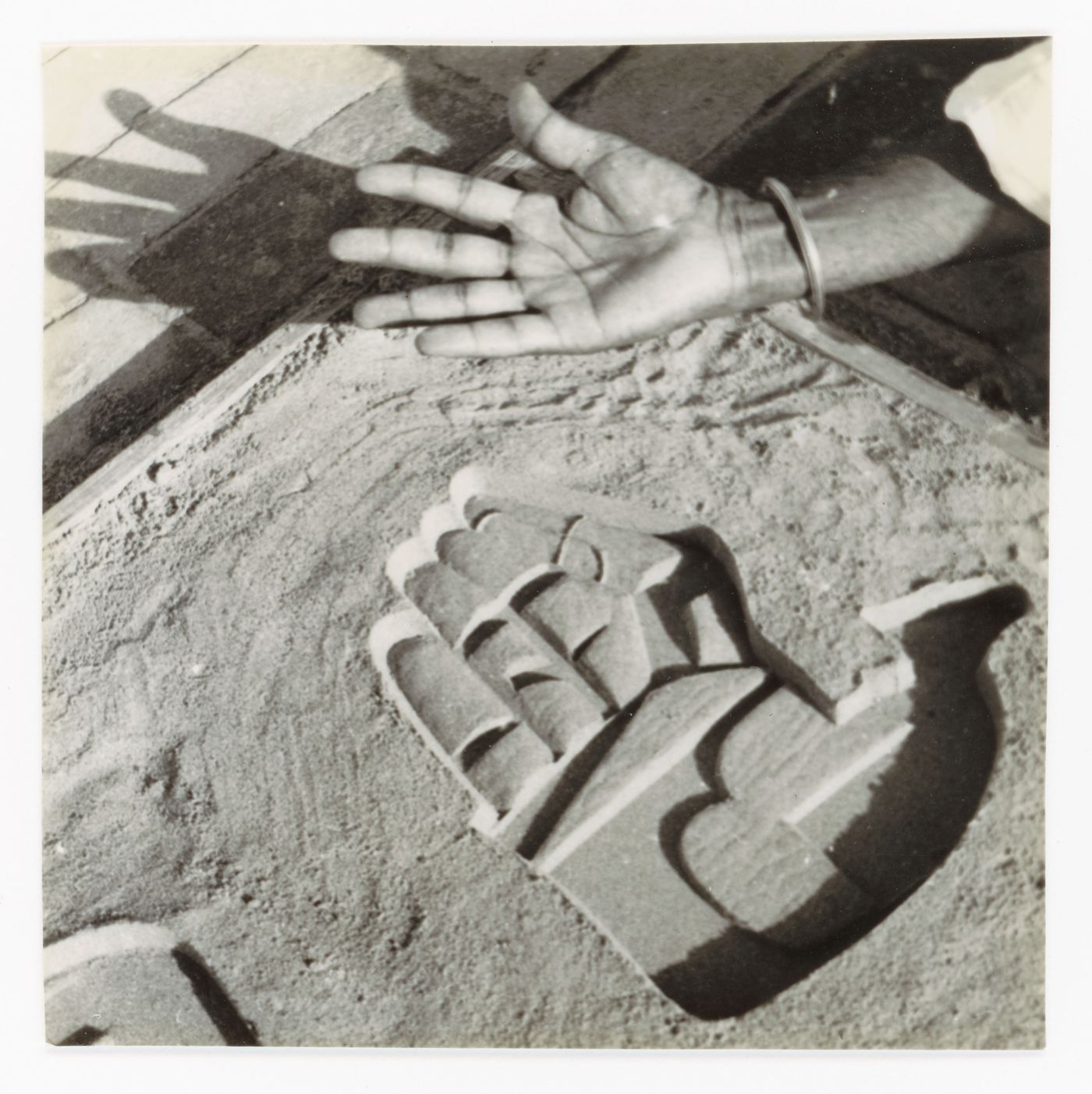 View of a bas-relief of an open hand sign by Le Corbusier and an unidentified right hand, Chandigarh, India