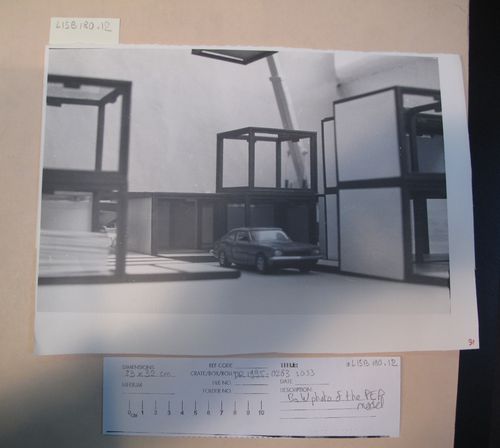 McAppy: view of elements from the model for the Portable Enclosures Programme (attached and stacked portable enclosures with car in foreground and crane in background)