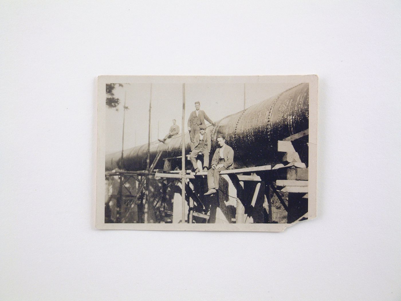 View of four men posing by a pipeline under construction, unknown location