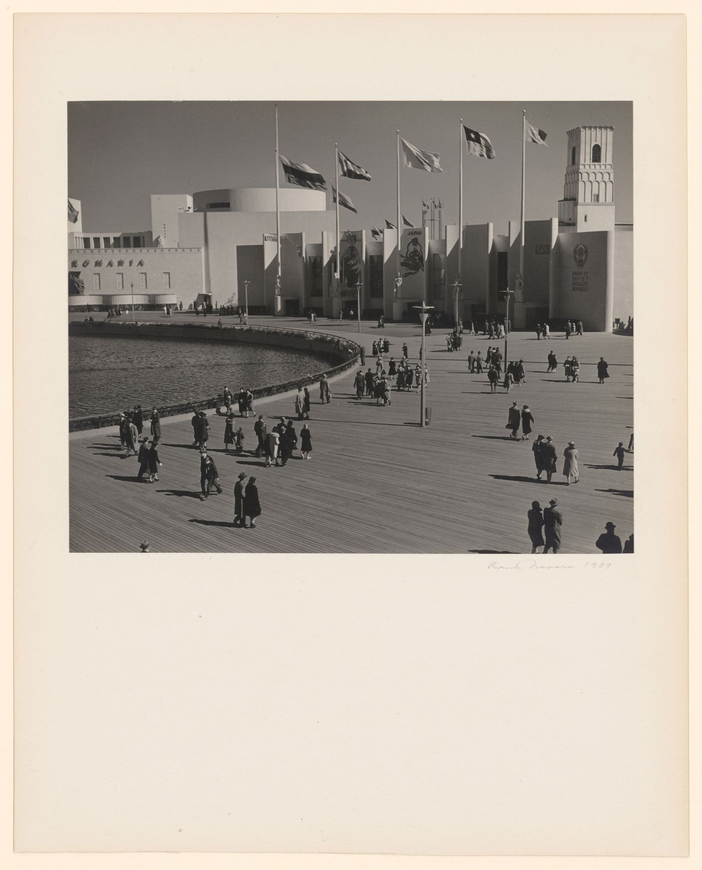 New York World's Fair (1939-1940): Crowds walking around Lagoon of Nations, Hall of Nations building group in background