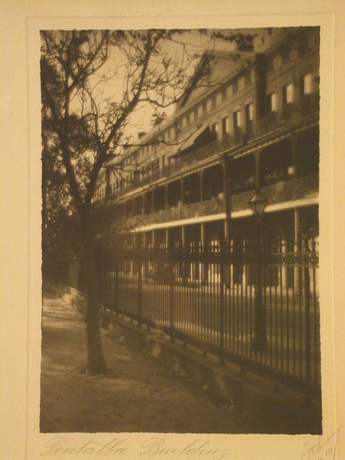 Side front view through iron gate of building with iron balconies/columns, New Orleans, Louisiana