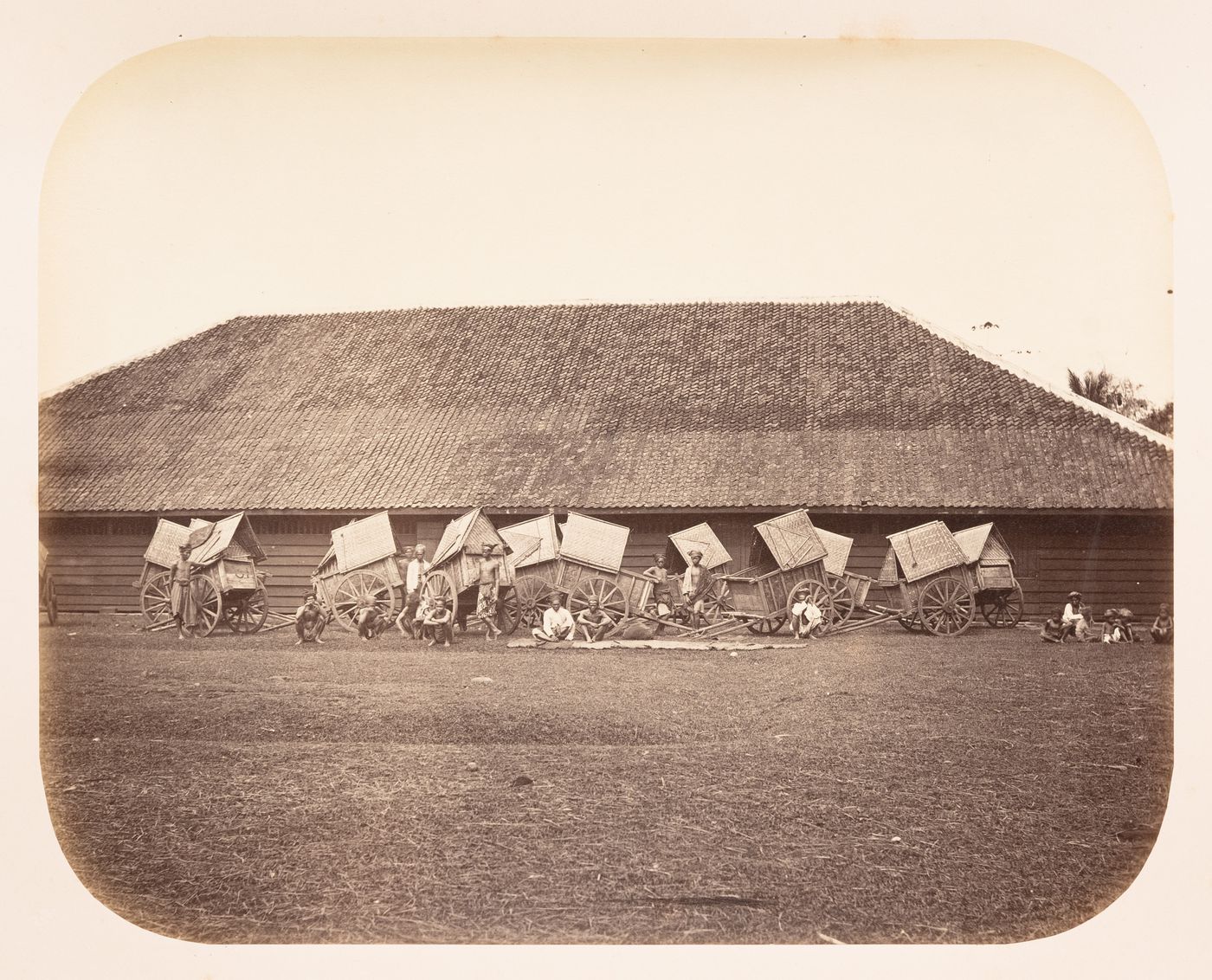 View of a building, carts and labourers, probably near Buitenzorg (now Bogor), the Preanger Regencies (now in Jawa Barat), Dutch East Indies (now Indonesia)