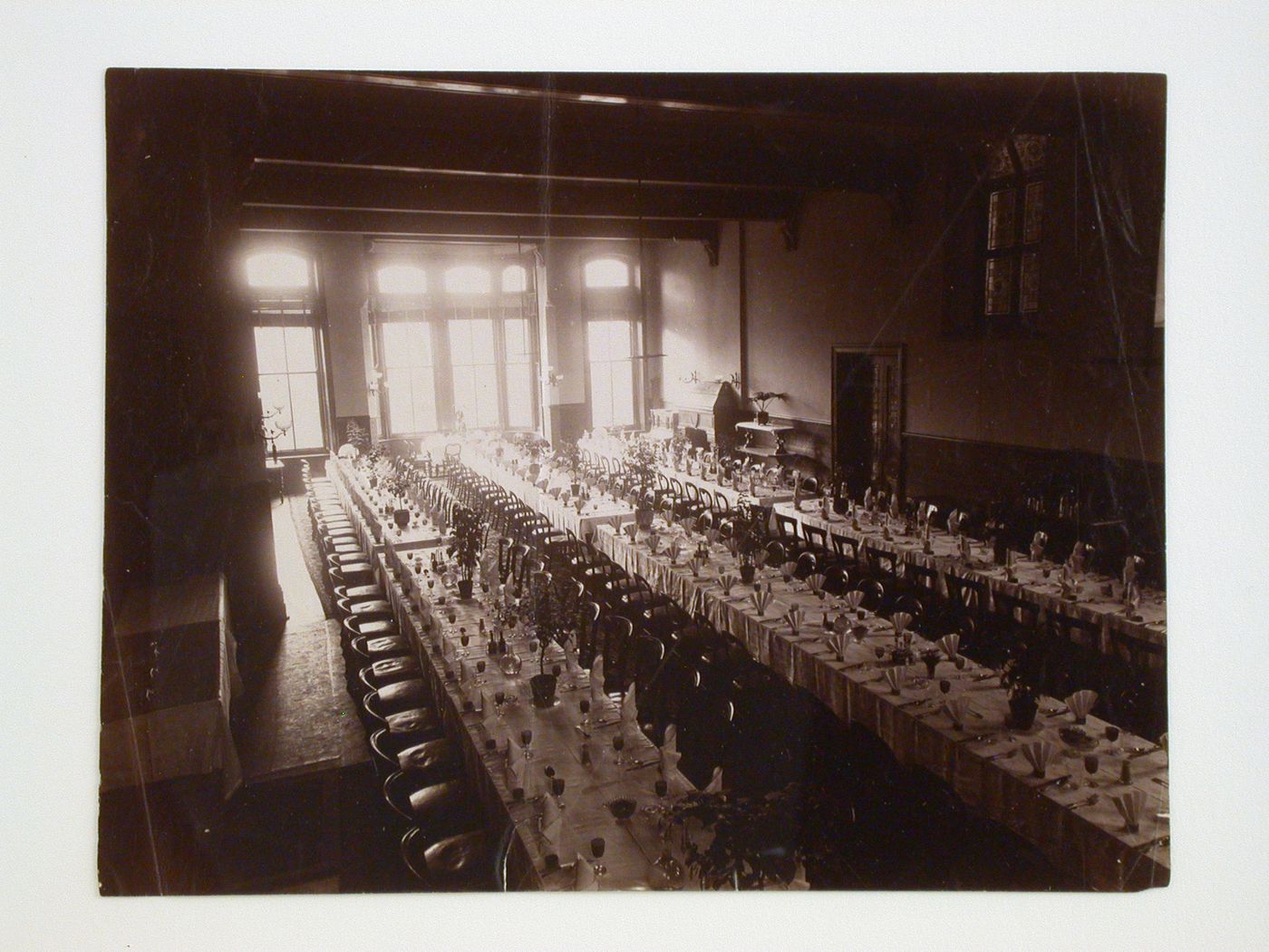 Interior view of a dining hall showing multiple tables with elaborate dinner settings, possibly in Derbyshire, England