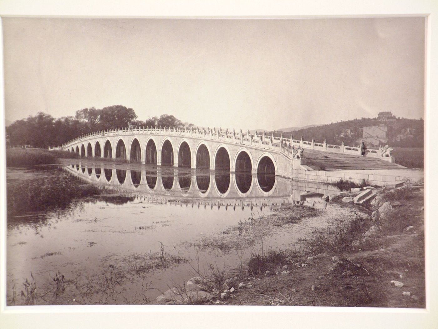 View of the Seventeen-Arch Bridge with Longevity Hill [Wanshou Shan] in the background, Garden of the Clear Ripples [Qing Yi Yuan] (now known as the Summer Palace or Yihe Yuan), Peking (now Beijing), China