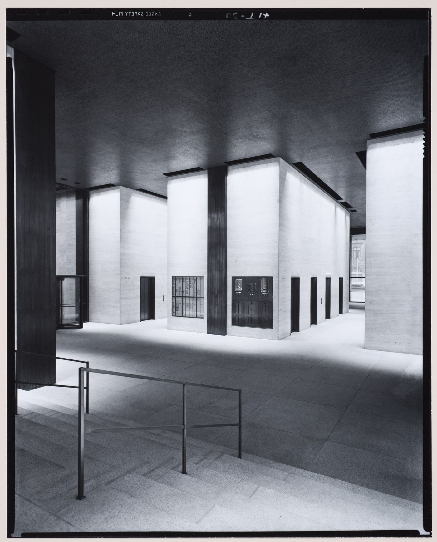 Interior view of the east lobby of the Seagram Building from the stairs showing the building directory and the elevators designed by Philip Johnson, New York City