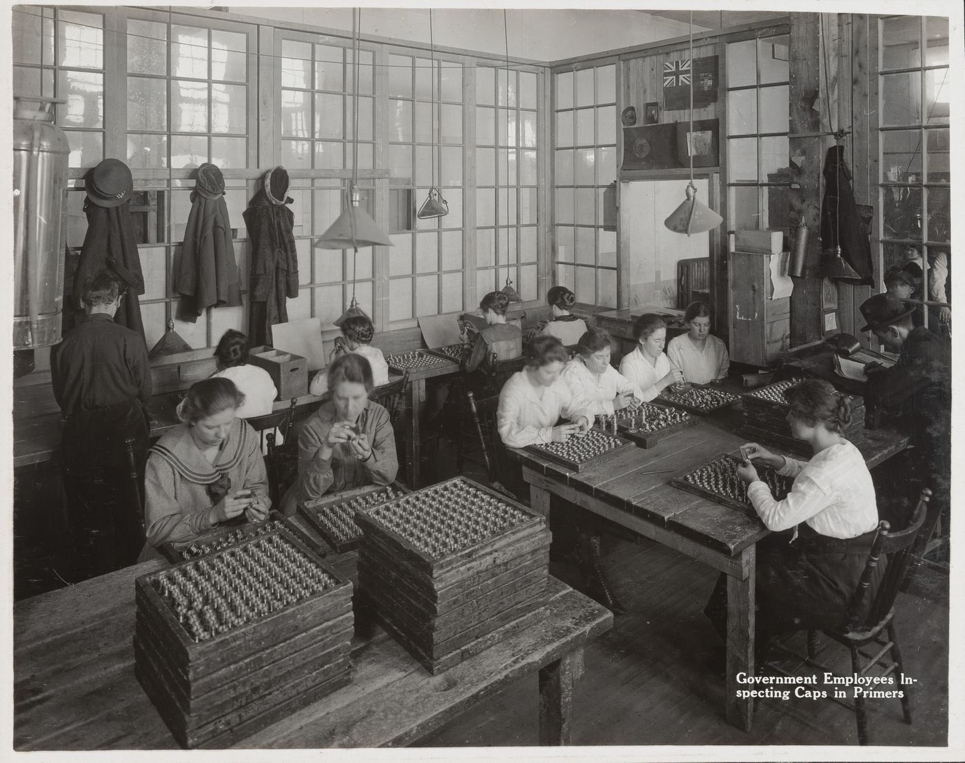 Interior view of workers inspecting caps in primers at the Energite Explosives Plant No. 3, the Shell Loading Plant, Renfrew, Ontario, Canada
