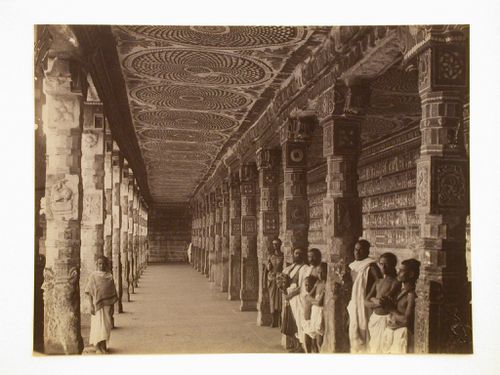 View of an aisle inside a temple with painted ceiling, columns and wall, and showing monks, Madura (now Madurai), India
