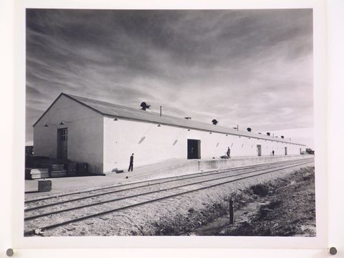 View of the principal and lateral façades of a warehouse showing the loading dock and train tracks, Consolidated Aircraft Corporation Assembly Plant, New Orleans, Louisiana