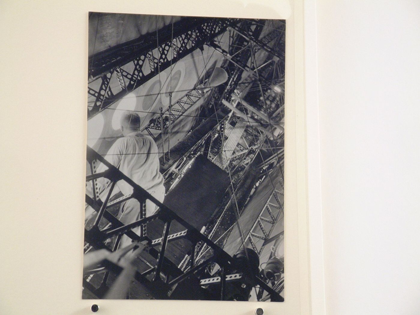 Interior view of a zeppelin showing the metal girders with a technician [?] looking out a porthole