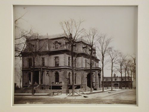 Three-quarter exterior view of Victorian stone building at intersection of tree-lined streets, Pullman, Illinois