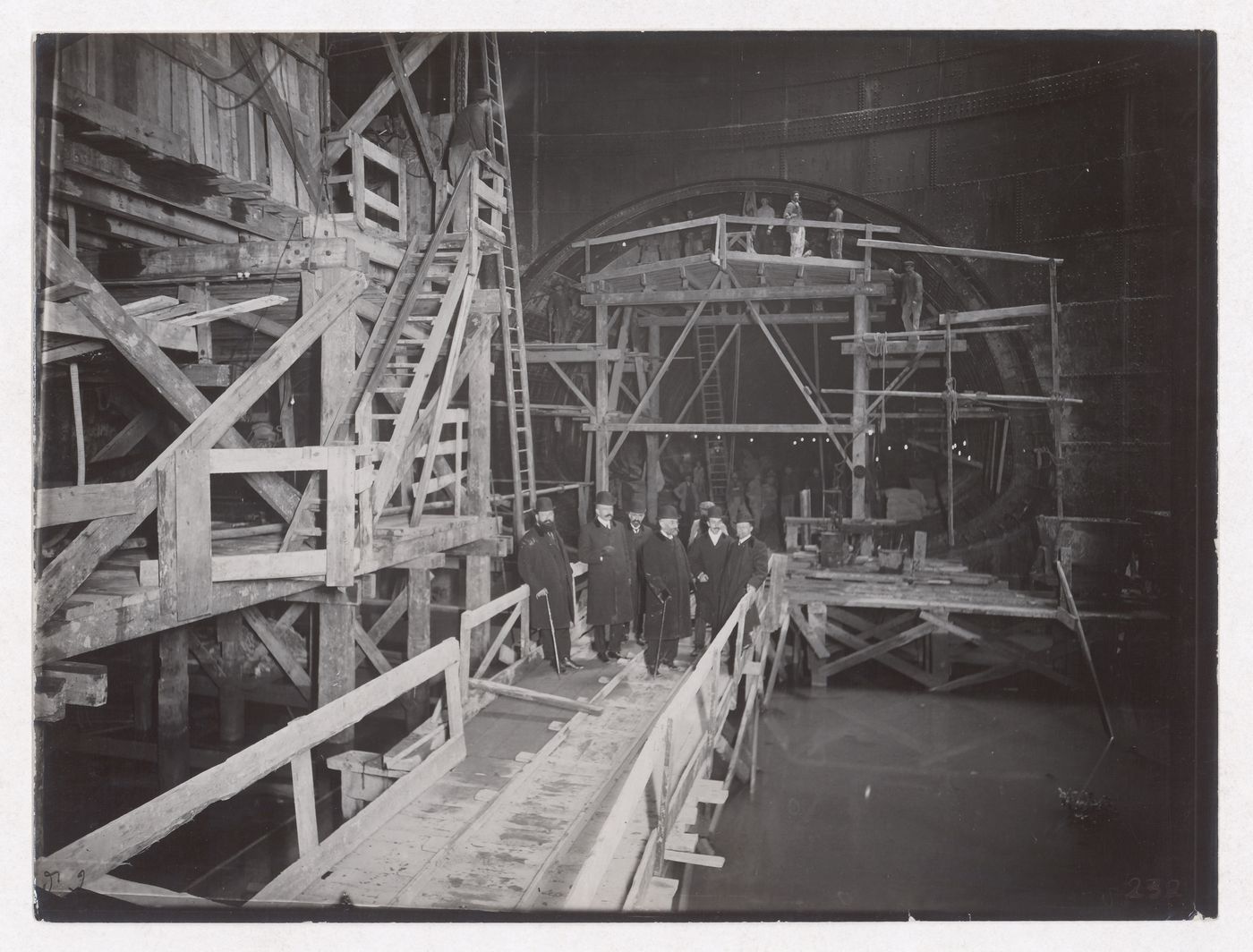 Construction of the Paris Metro, interior view with men standing on constructed walkways, Paris, France