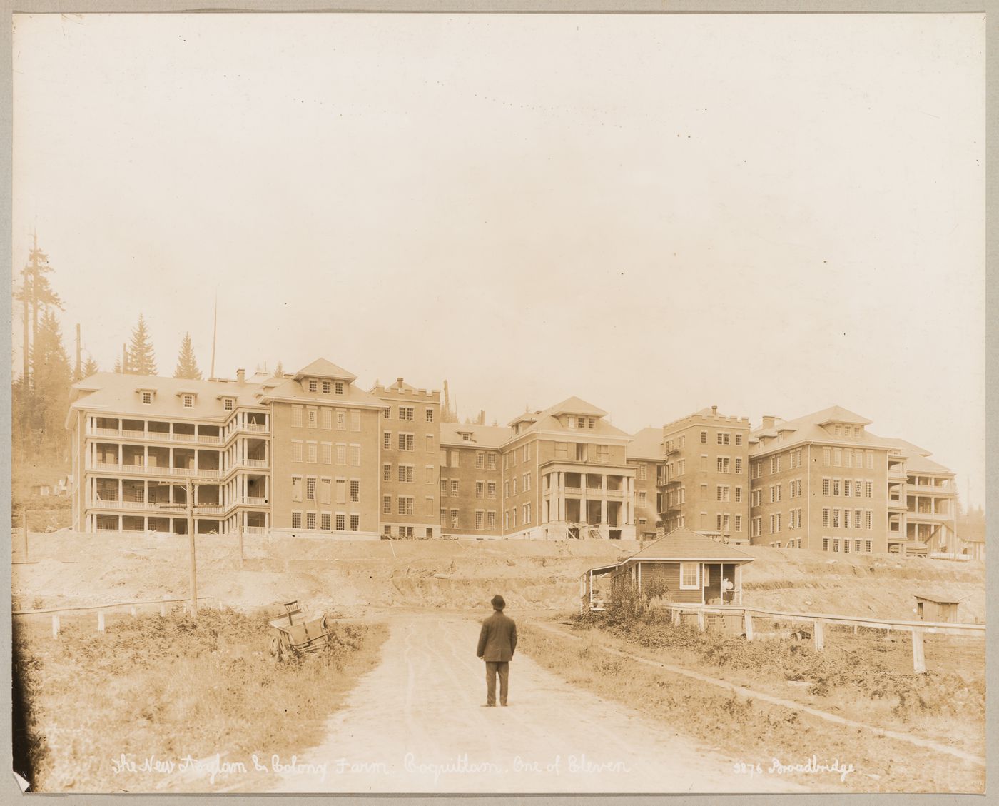 View of principal façade of the Provincial Asylum with the Provincial Government Demonstration Farm (also known as the Colony Farm) on the right, Coquitlam (now Port Coquitlam), British Columbia, Canada