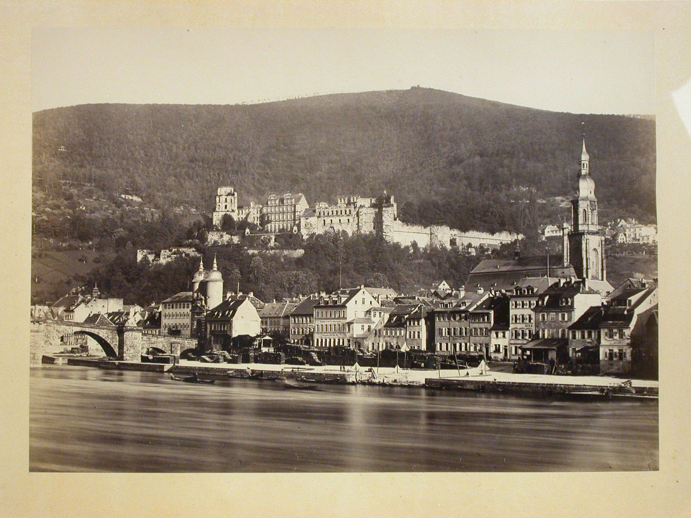 View across river of city, with church on right and castle [?] on hill behind city, Heidelberg [?], Germany
