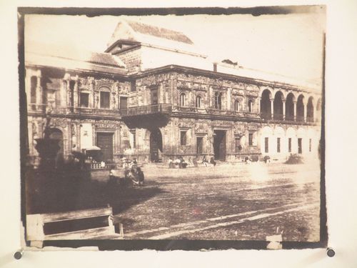 Guard house [?] three quarter view with figures in square, Seville, Spain