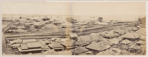 Panorama of the harbour area showing buildings, building sites, roads, a waterway, and sailing ships, Kannai district, Yokohama, Japan
