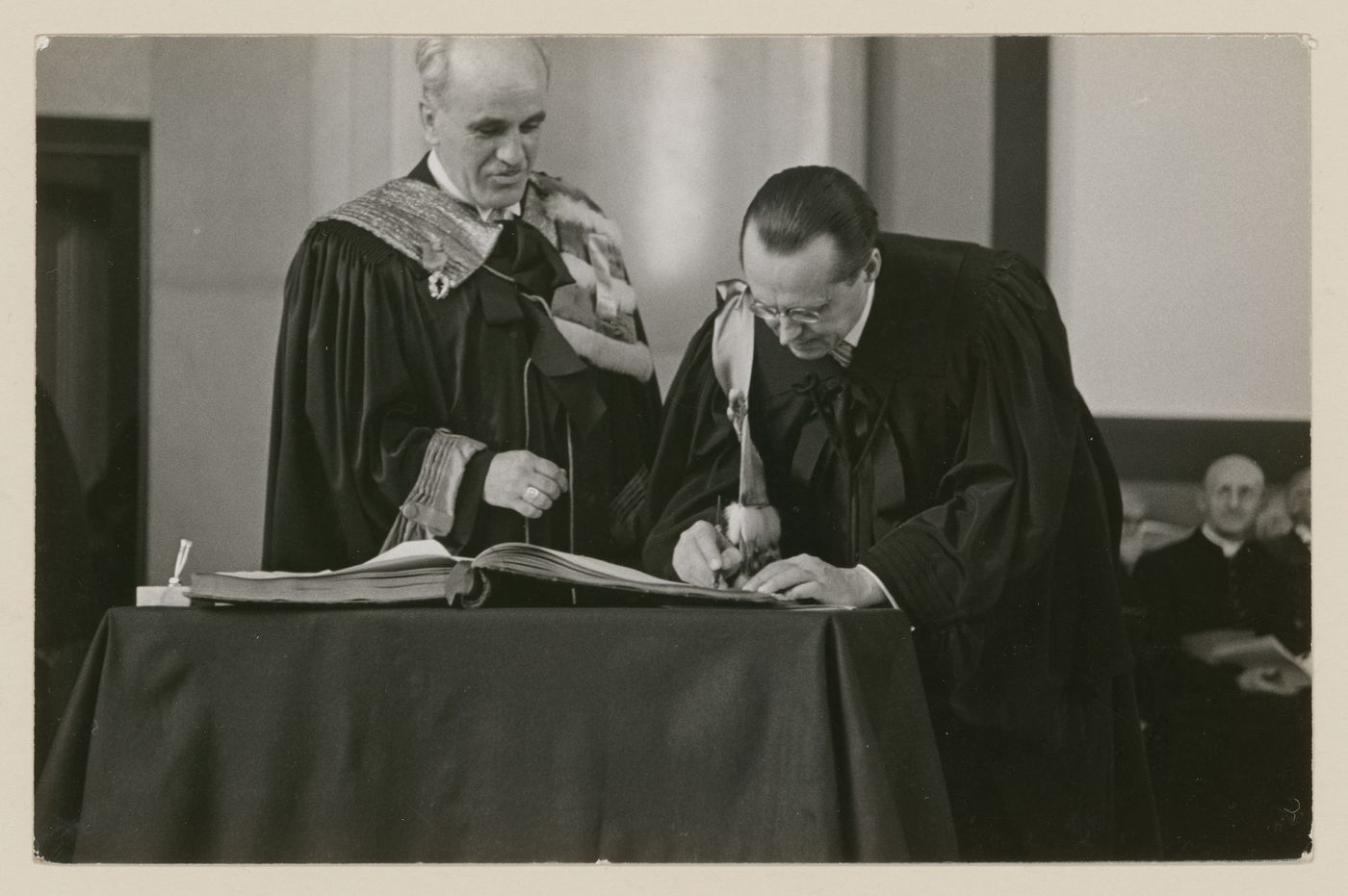 Portrait d'Ernest Cormier signant un document lors de l'inauguration officelle de l'immeuble de l'Université de Montréal, le 3 juin 1943