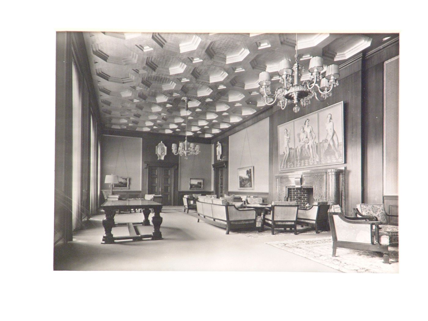 Interior of large room, with coffered ceiling and painted triptych above fireplace