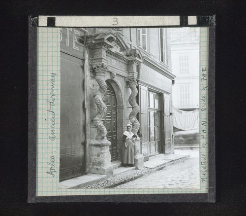 View of woman leaning on base of column of ancient doorway, Arles, France
