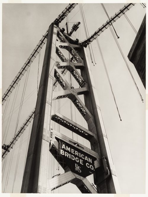 San Francisco - Oakland Bay Bridge under construction showing bridge tower with AMERICAN BRIDGE CO. and US STEEL sign and cranes, San Francisco, California