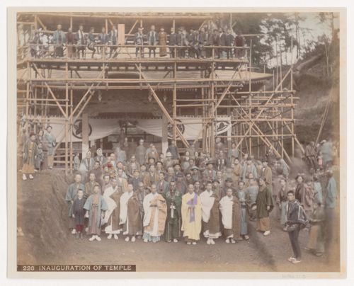 Group portrait of people in front of a newly inaugurated shrine or temple with scaffolding, Japan