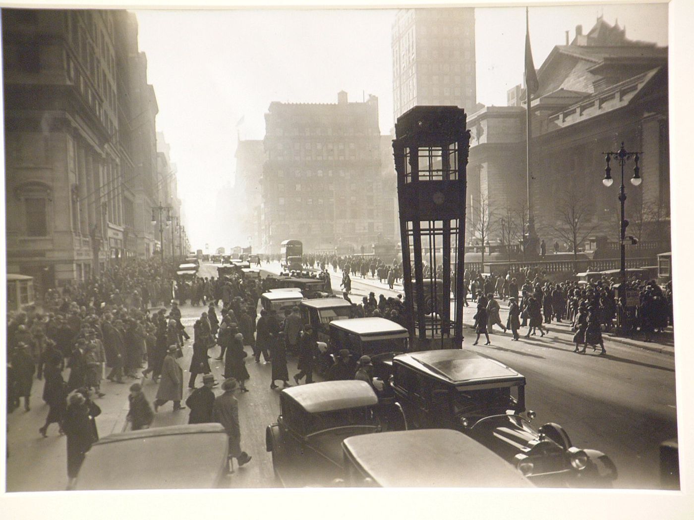 Pedestrians and cars on Fifth Avenue, with New York Public Library on right, New York city, New York