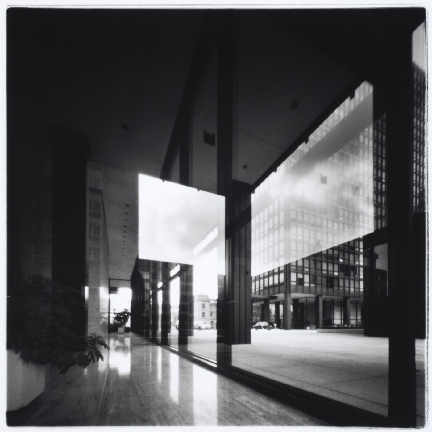 Interior view of the west tower showing a windowed ground floor corridor with a plaza and the north tower in the background, Westmount Square, Westmount, Québec, Canada