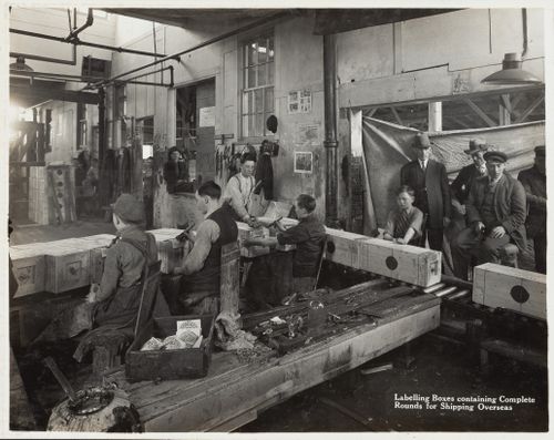 Interior view of workers labelling boxes containing complete rounds for shipping at the Energite Explosives Plant No. 3, the Shell Loading Plant, Renfrew, Ontario, Canada