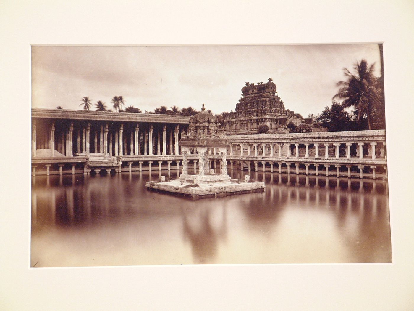 View of a pavilion in a water tank surrounded by a colonnades with a gopura in the background, Shaiva Jambukeshvara Temple, Seringham (now Srirangam), India