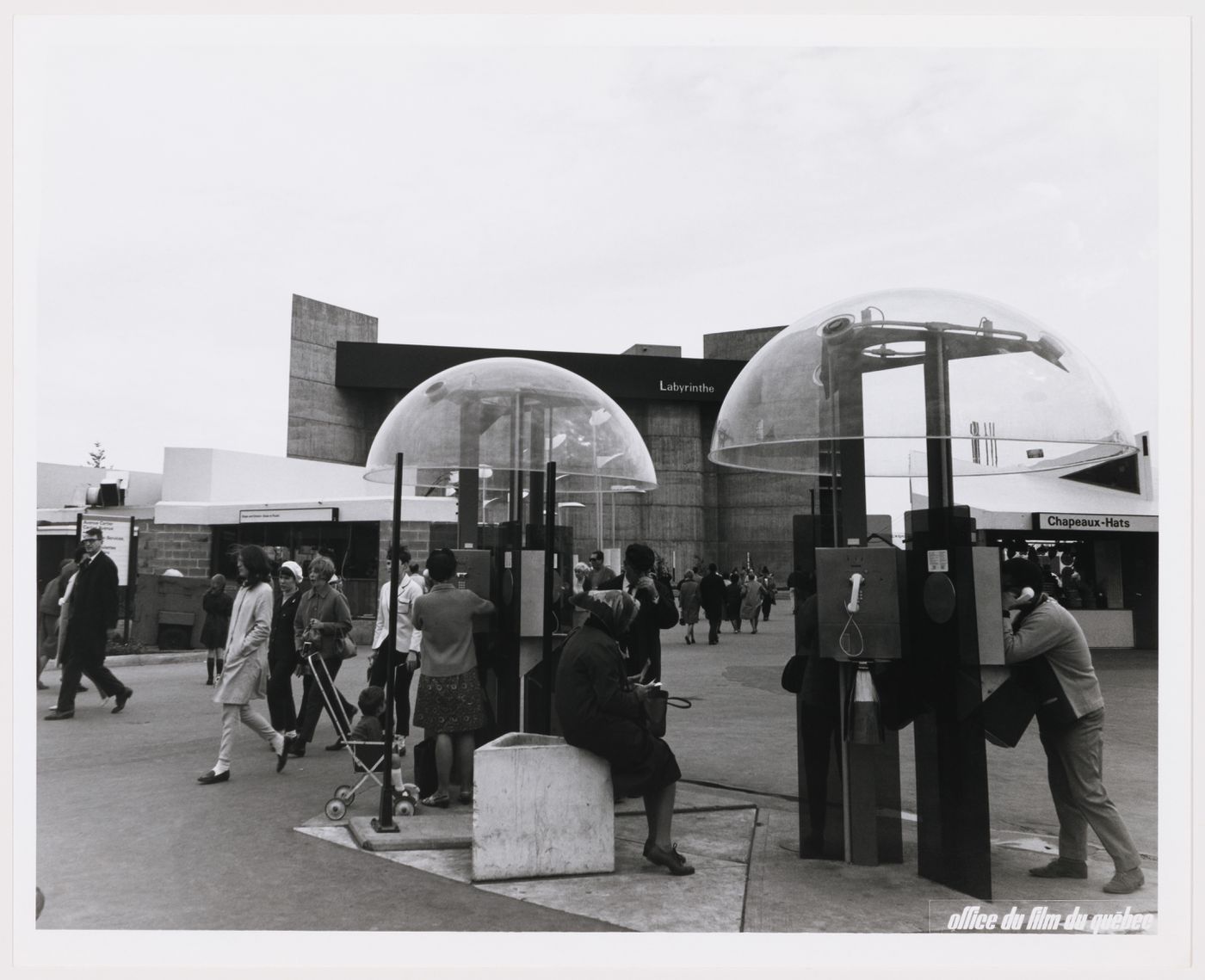View of telephone booths with the Labyrinth Pavilion in background, Expo 67, Montréal, Québec
