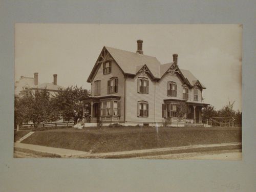 Large wooden house with two porches, decorative bargeboards and shutters