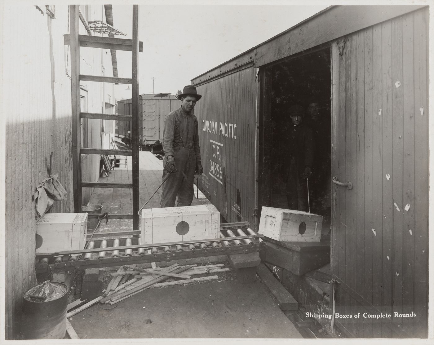 Exterior view of workers shipping boxes of complete rounds at the Energite Explosives Plant No. 3, the Shell Loading Plant, Renfrew, Ontario, Canada