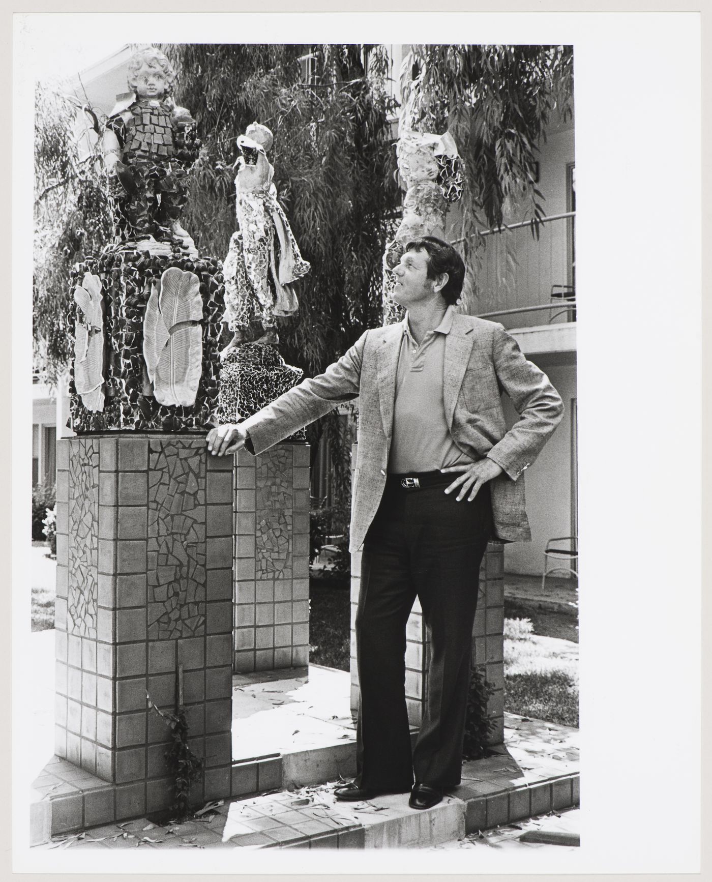 Portrait of Gene Summers standing next to a statue