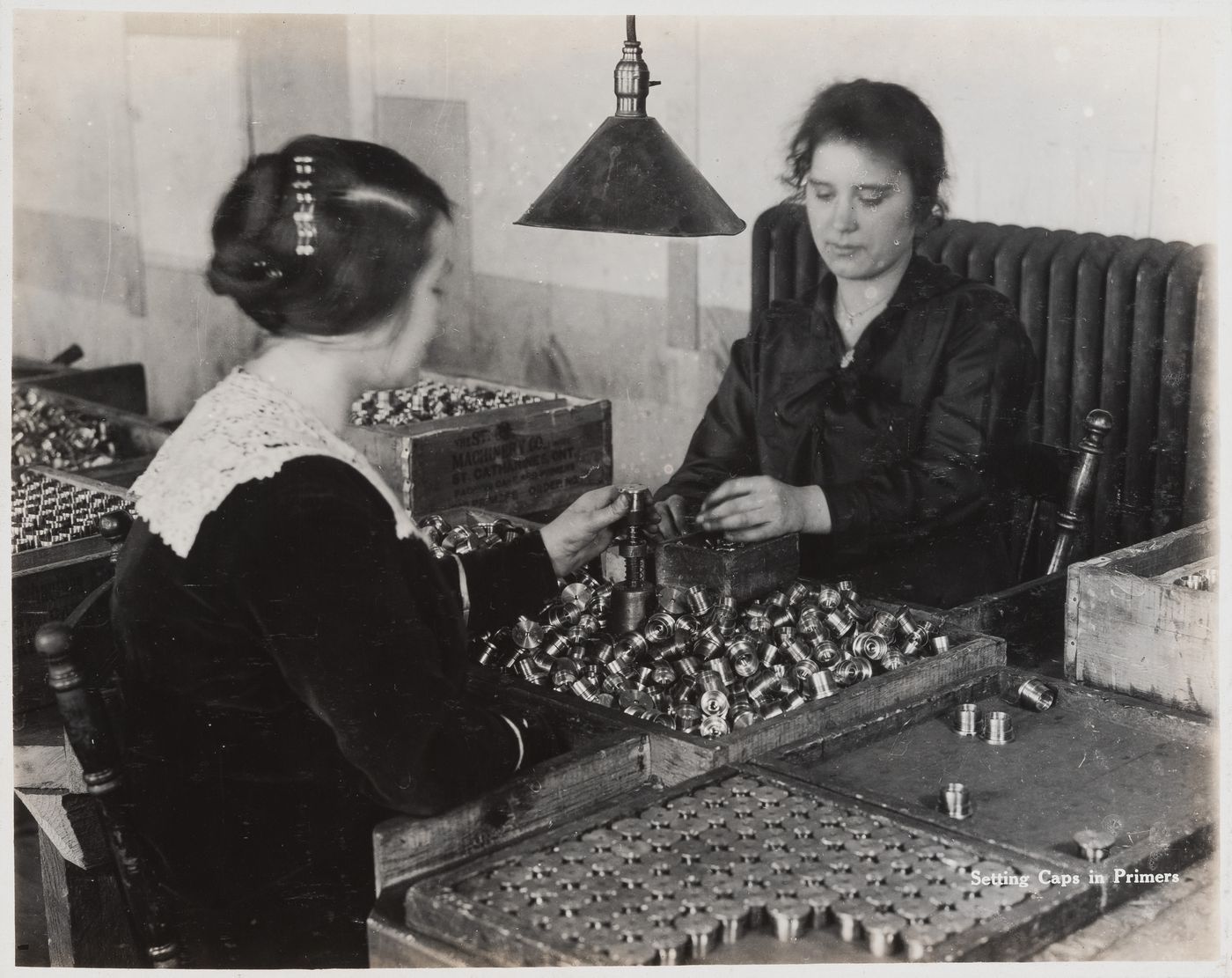 Interior view of workers setting caps in primers at the Energite Explosives Plant No. 3, the Shell Loading Plant, Renfrew, Ontario, Canada