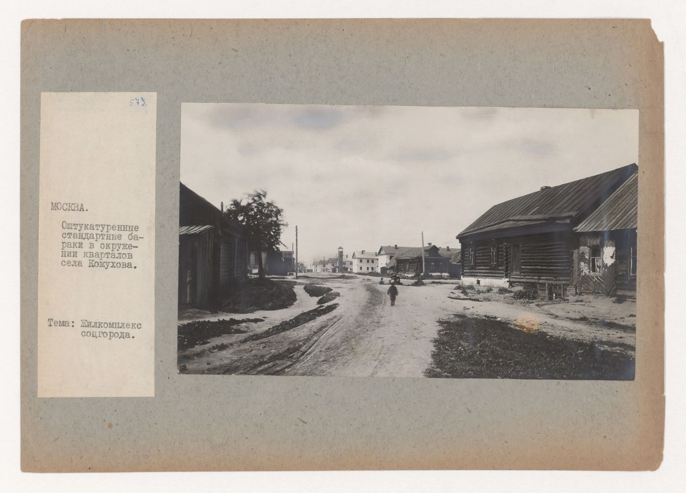 View of a street showing old wooden houses and new barracks in the background, Kozhukhovo (now Moscow)