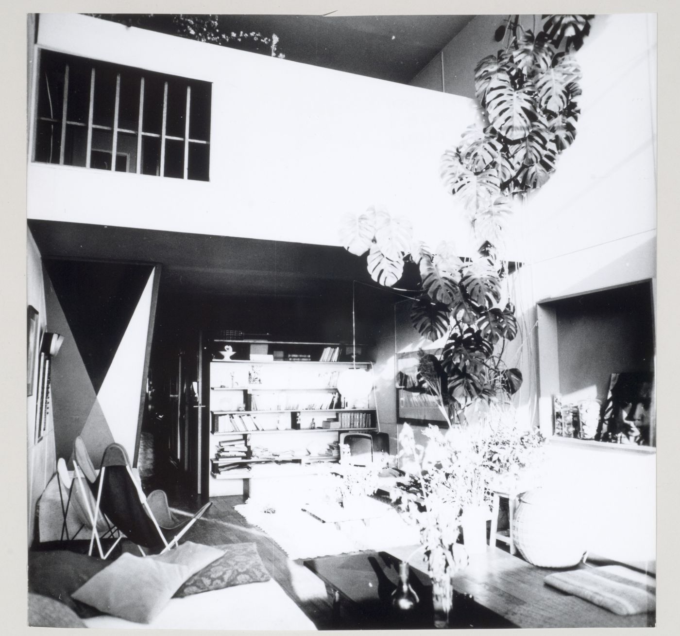 Interior view of an apartment living room showing built-in shelves, tables, chairs, and houseplants, Unité d'habitation, Marseille, France