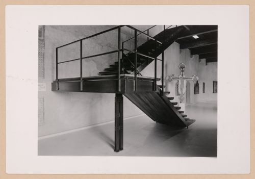Interior view of a gallery showing a staircase with a freestanding painted crucifix and paintings in the background, Museo di Castelvecchio, Verona, Italy