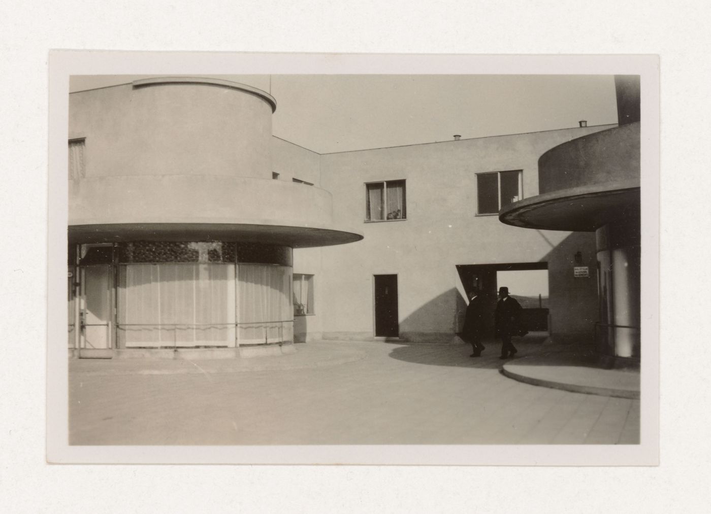 Exterior view of industrial row houses showing corner stores, a covered walkway and the library, Hoek van Holland, Netherlands