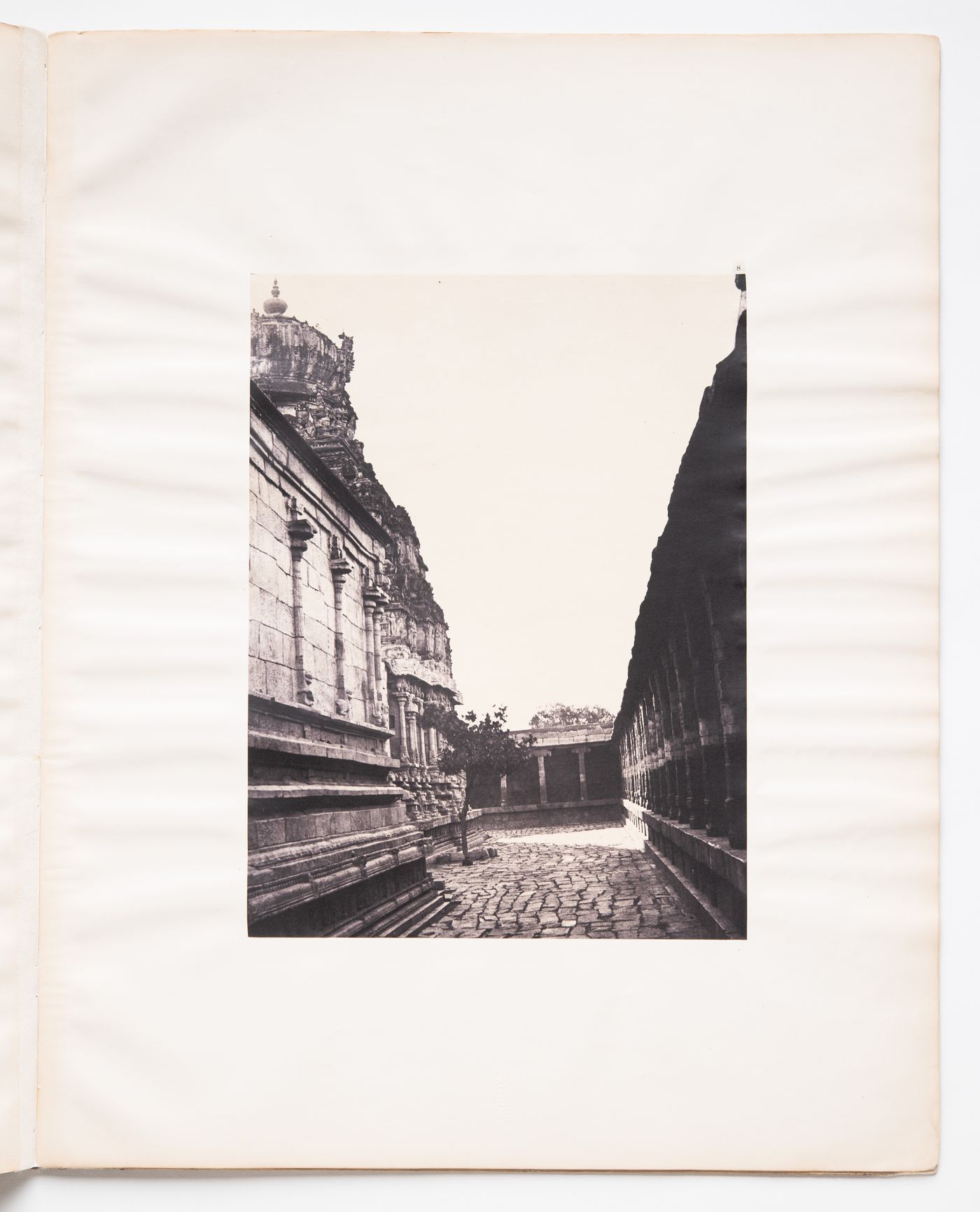 View of a paved path showing part of the Sundareswara temple on the left and part of a gopura [?] on the right, Madura (now Madurai), India