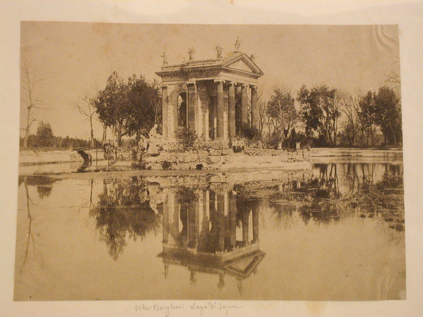 Greek/Roman temple with Ionic columns and statues on the roof (maybe Temple of Aesculapius) on a lake, Rome, Italy