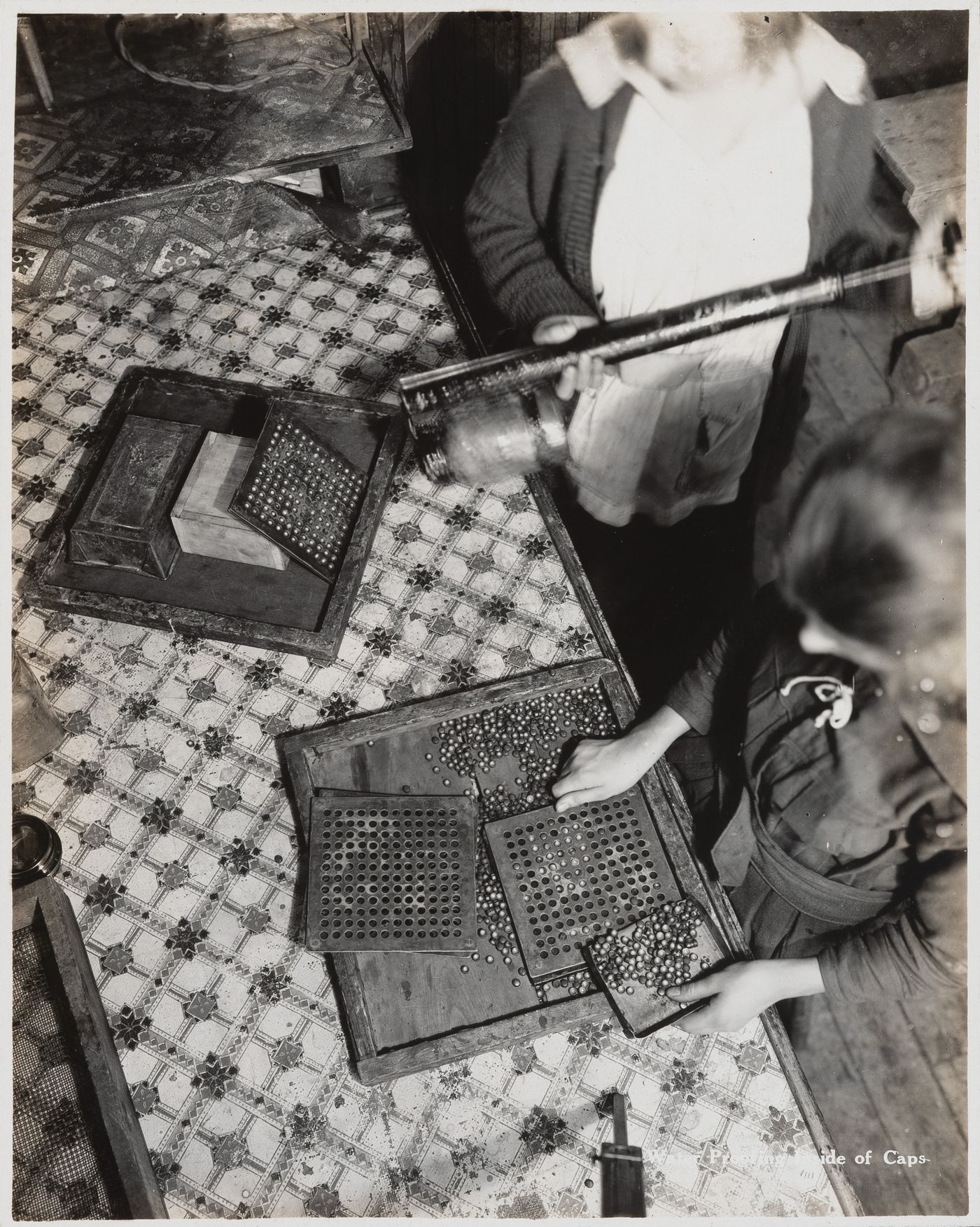 Interior view of workers waterproofing inside of caps at the Energite Explosives Plant No. 3, the Shell Loading Plant, Renfrew, Ontario, Canada