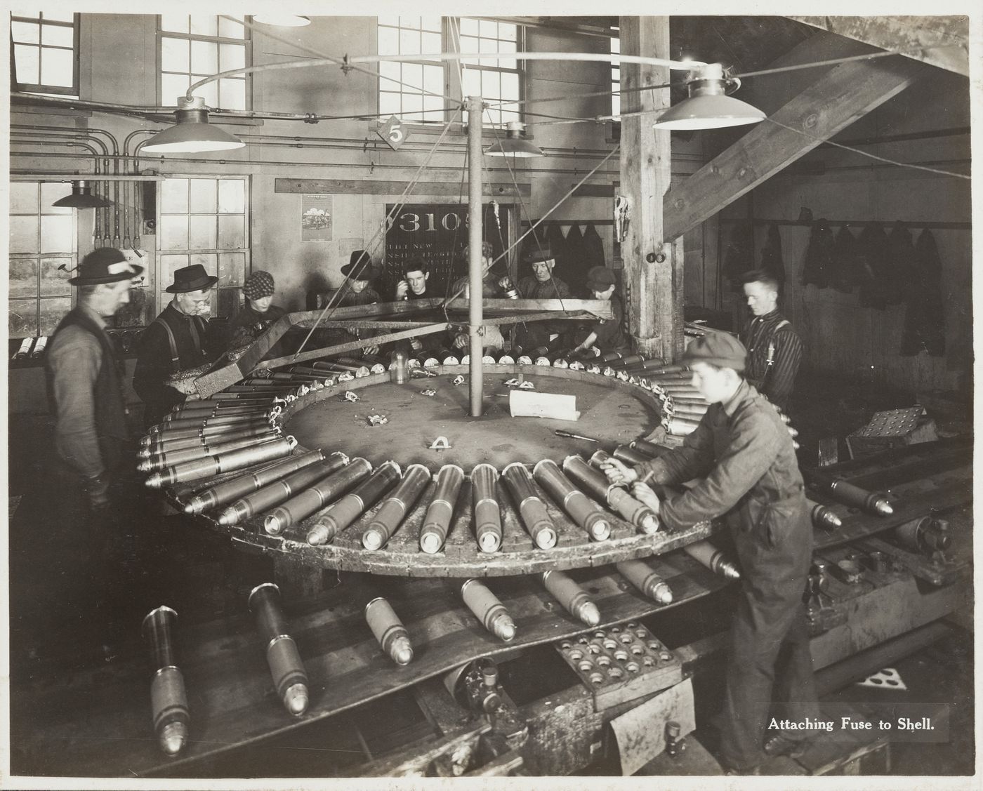 Interior view of workers attaching fuses to shells at the Energite Explosives Plant No. 3, the Shell Loading Plant, Renfrew, Ontario, Canada