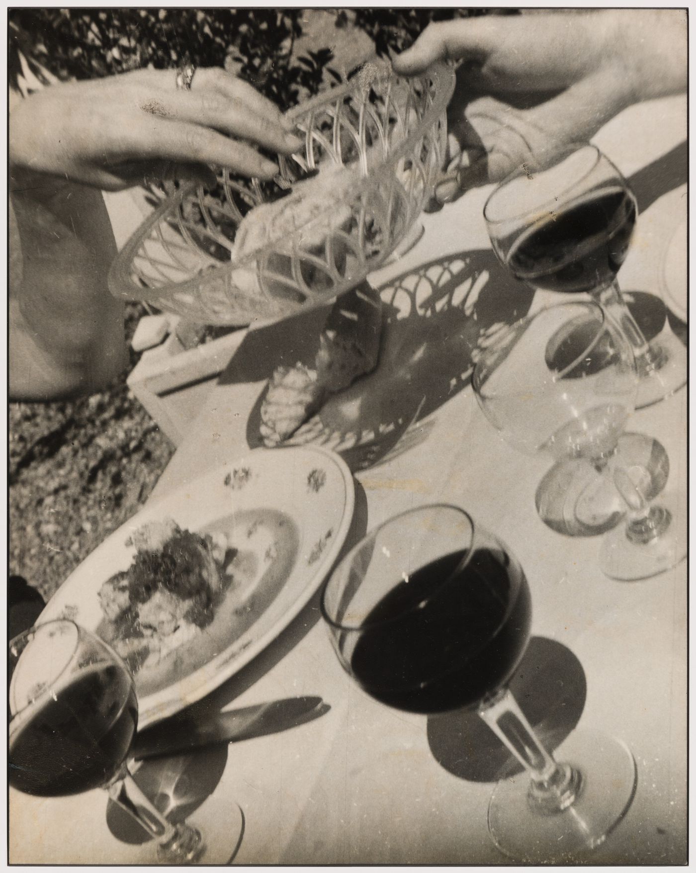 The hands of architects Arthur Erickson and Guy Desbarats during a meal in France [Pass the Bread, Please!]