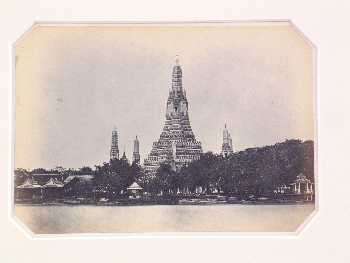 View of the Wat `Arunratchawararam (also known as Wat Arun) temple complex showing the phra prang and other stupas and the Chao Phraya River, Bangkok, Siam (now Thailand)