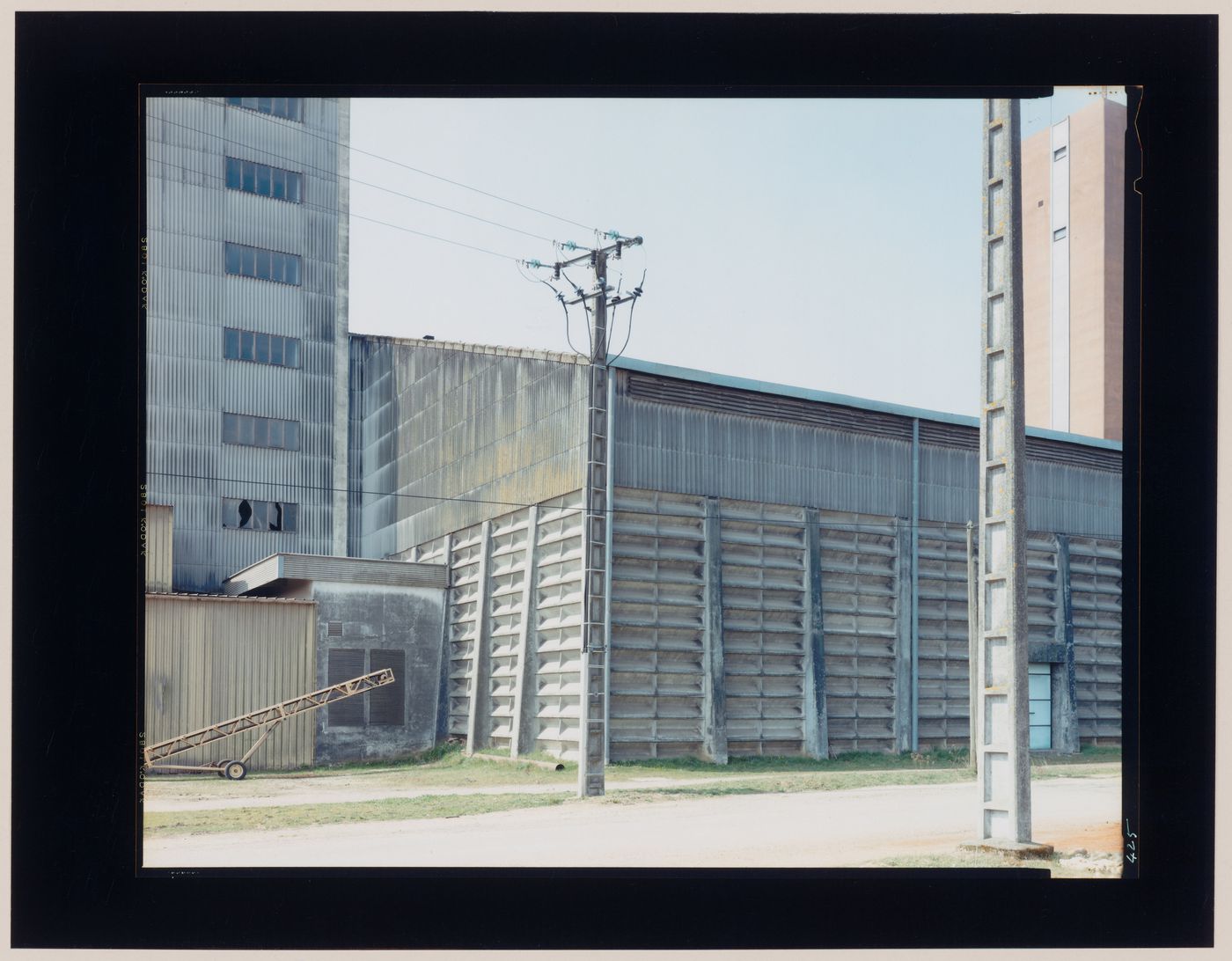 View of agricultural buildings and utility poles, La Villedieu, near Niort, France (from the series "In between cities")