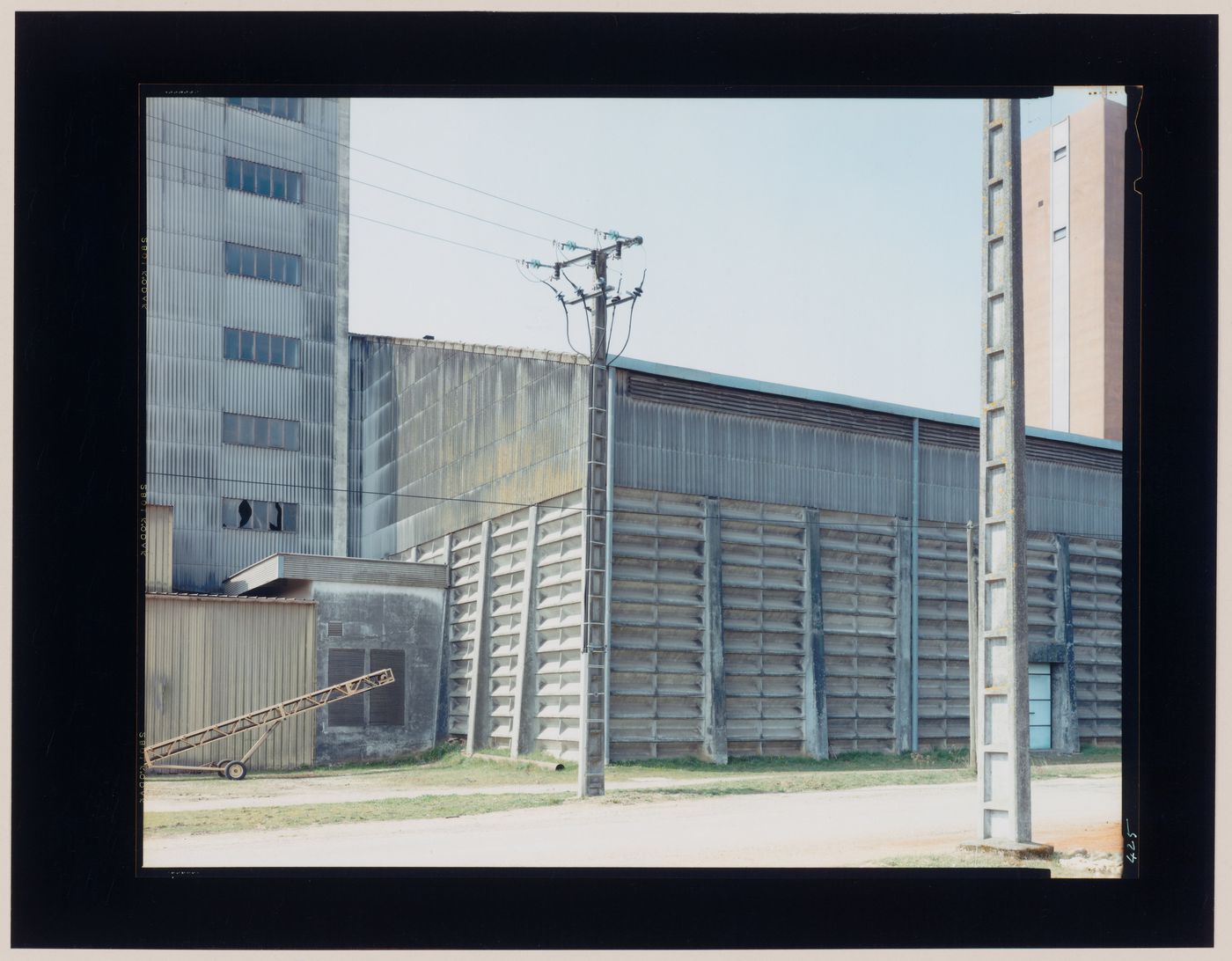 View of agricultural buildings and utility poles, La Villedieu, near Niort, France (from the series "In between cities")