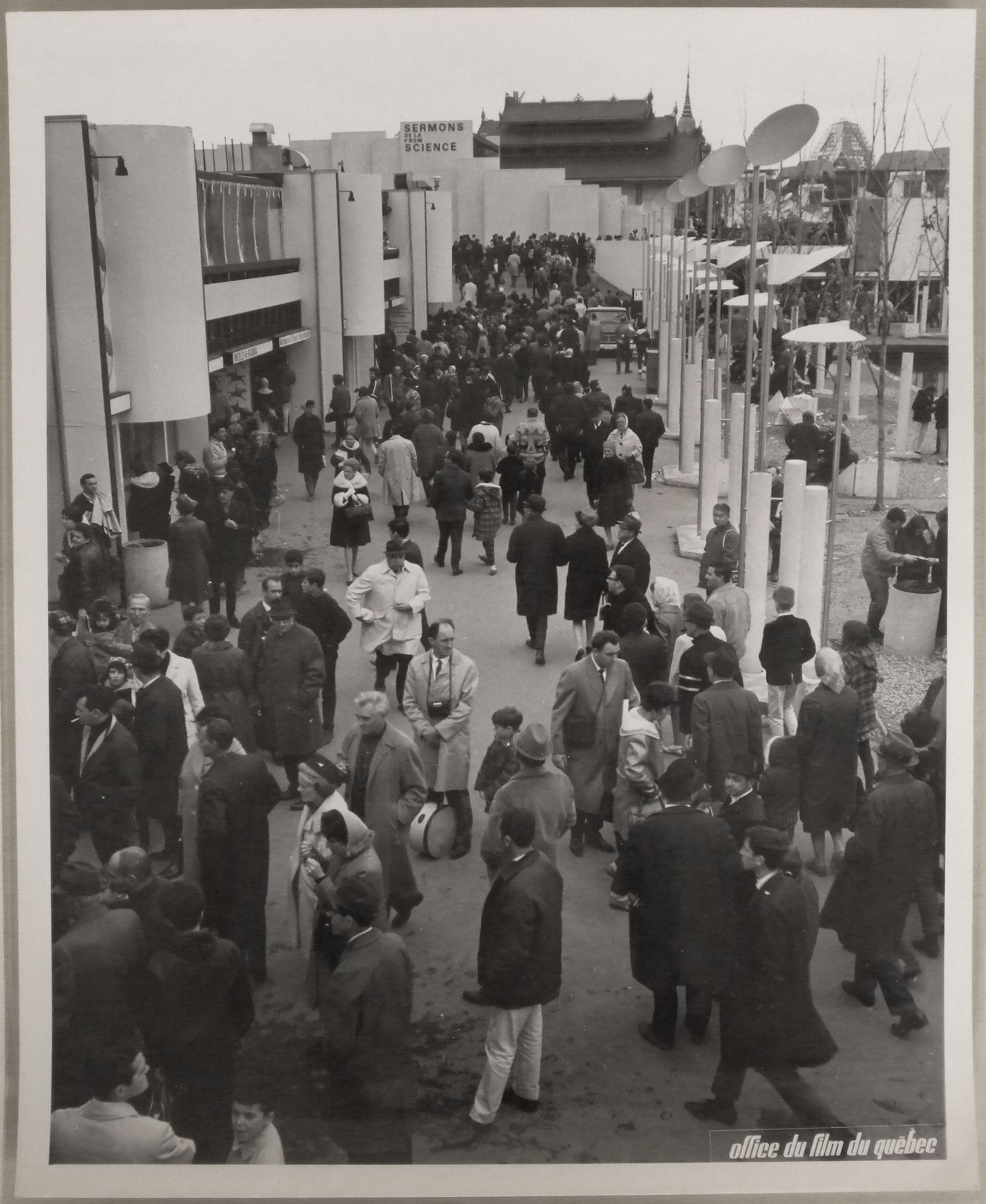 View of the walkway of the Expo-Service C with the Sermons from Science Pavilion in background, Expo 67, Montréal, Québec