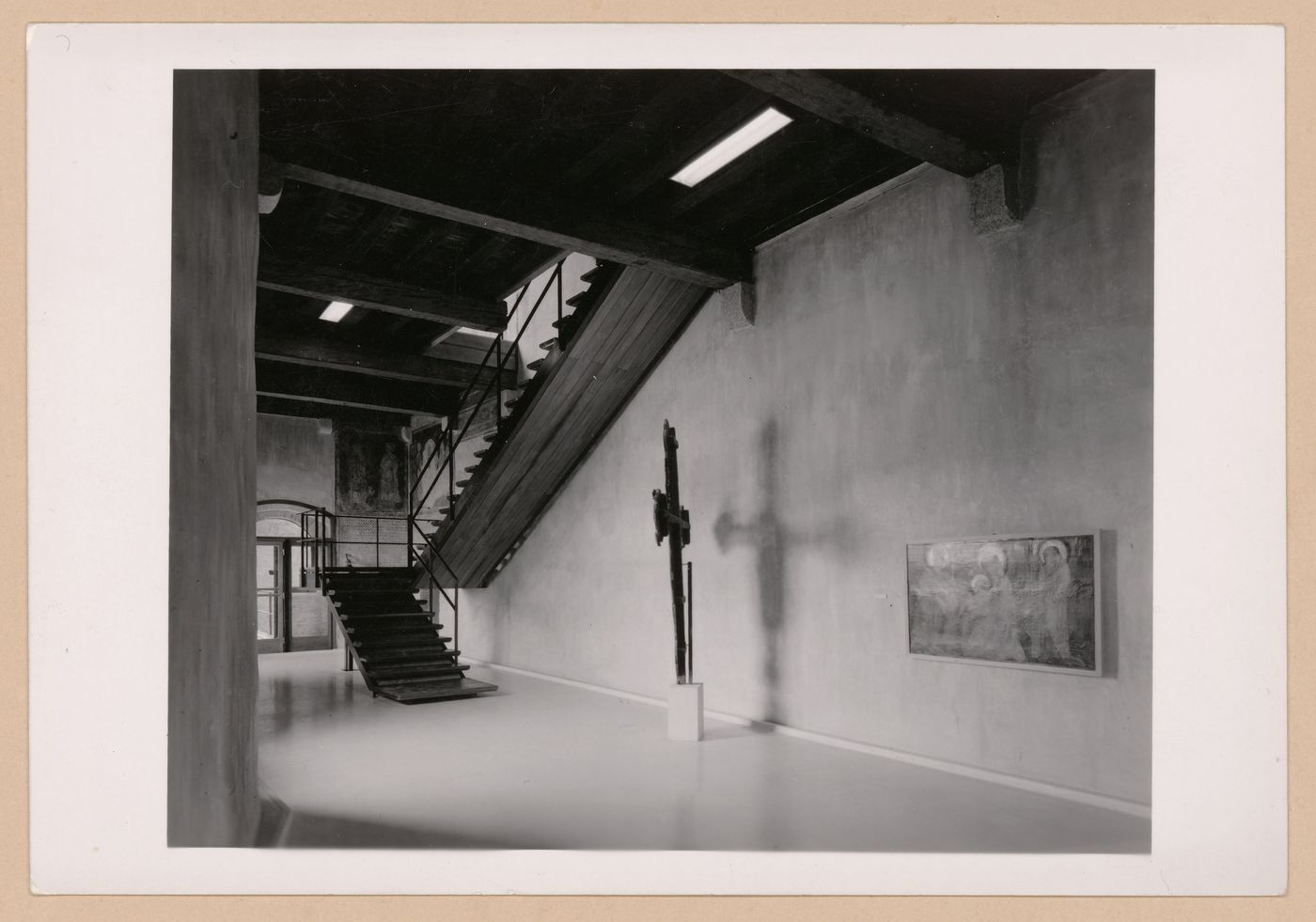 Interior view of a gallery showing  with a staircase, a freestanding painted crucifix and a painting, Museo di Castelvecchio, Verona, Italy