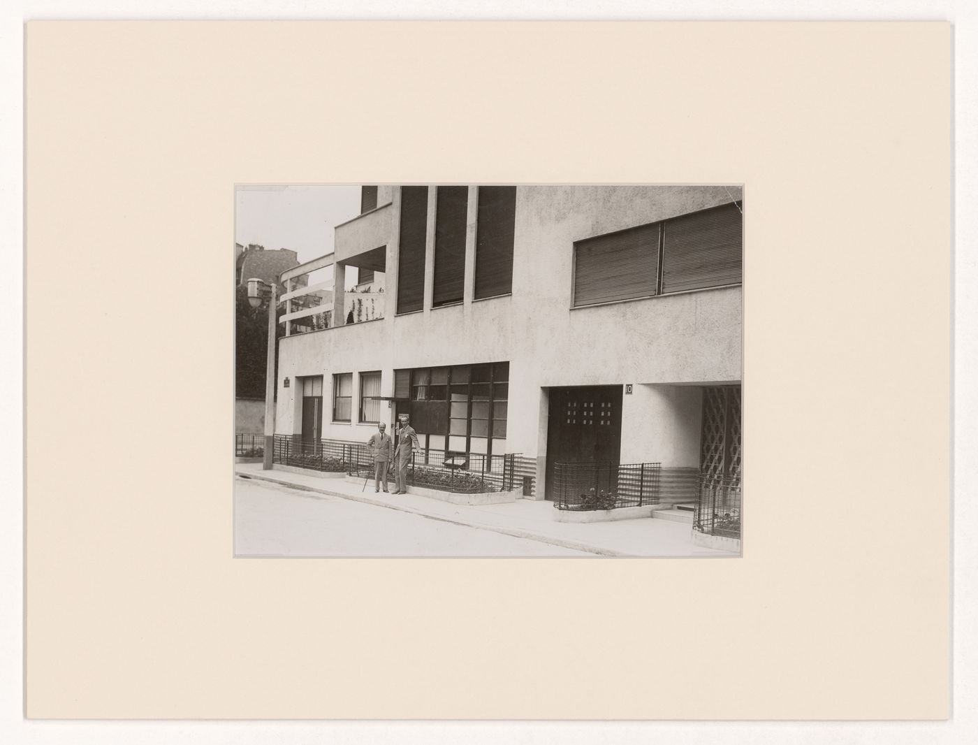 View of Robert Mallet-Stevens and another man in front of his hôtel particulier on rue Mallet-Stevens, 16th arrondissement, Paris, France