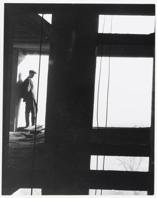 Interior view of Unité d'habitation under construction showing a worker standing within the reinforced concrete structural frame, Marseille, France